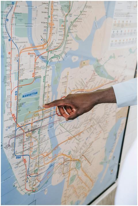 Close-up of a hand pointing at a Manhattan subway