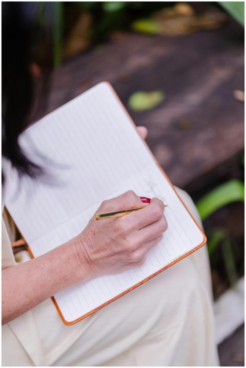 Close-up of a woman writing in a notebook while si