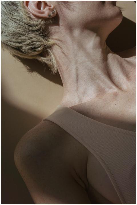 Crop unrecognizable female in beige top lying on f