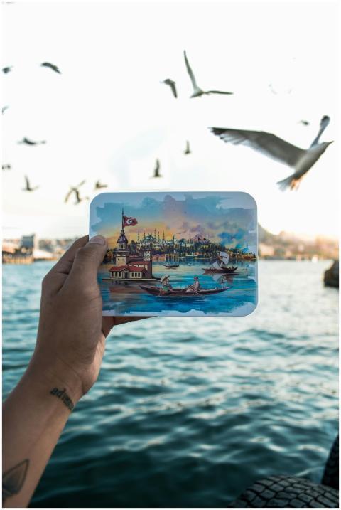 A hand holds an illustrated scene of Istanbul with