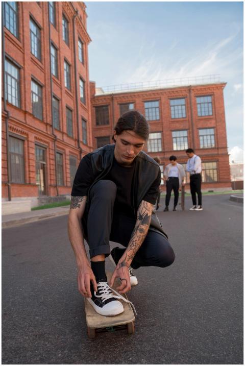 A young man sitting on a skateboard in a city sett
