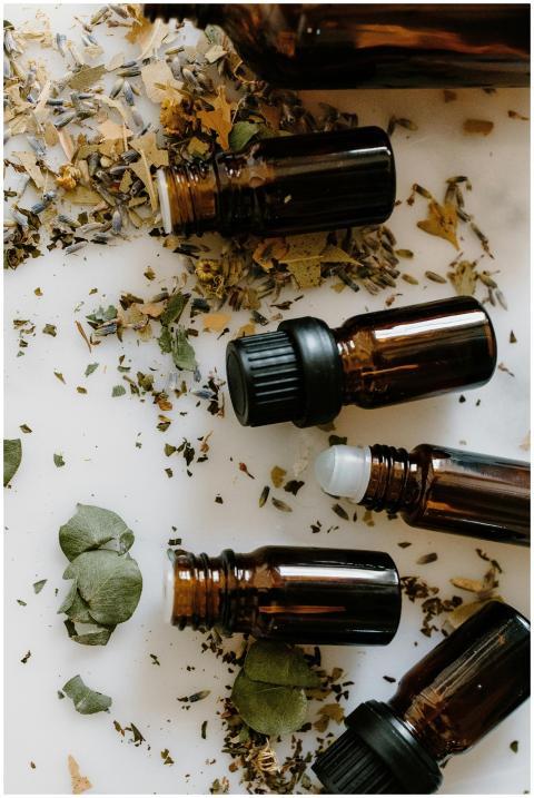 Flat lay of amber glass bottles and dried herbs fo