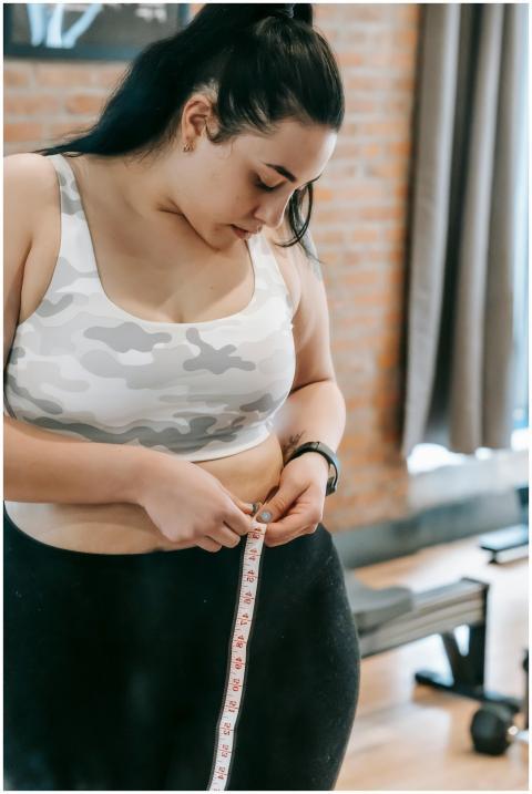 Young obese female using tape for evaluating size