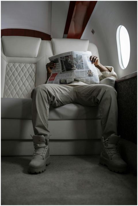 A man reading a newspaper while seated in a luxuri