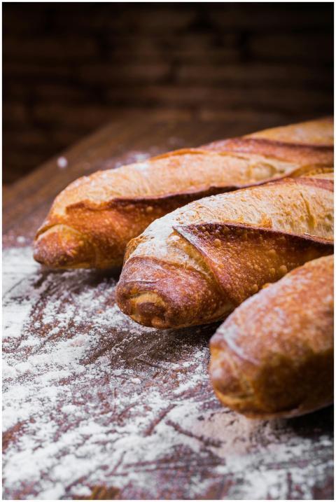 Close-up of fresh, golden-brown baguettes dusted w