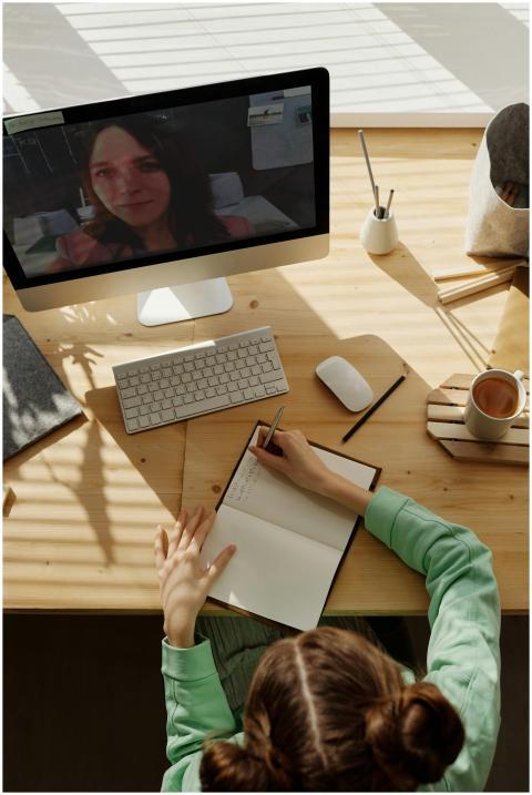 A teenager attends an online class from home, taki