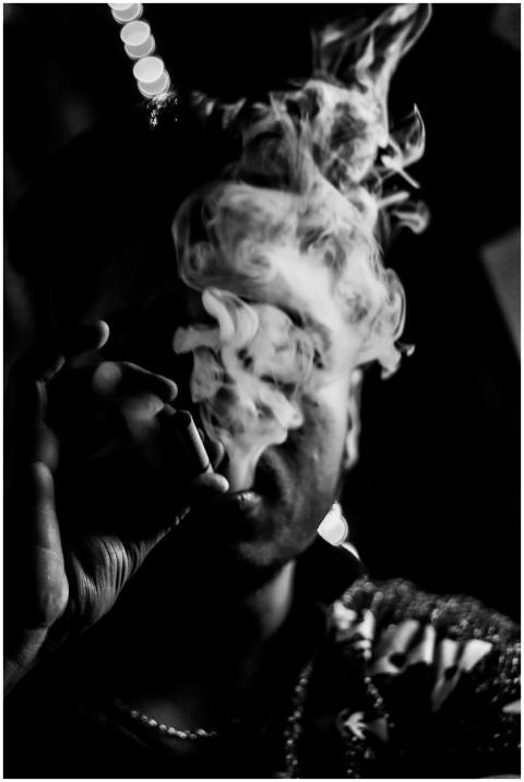 Man smoking with smoke obscuring face, captured in