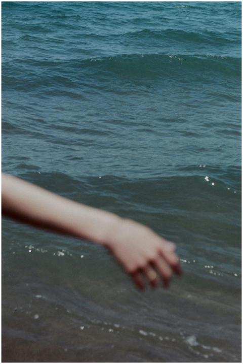 Blurry hand reaching over the ocean waves, creatin