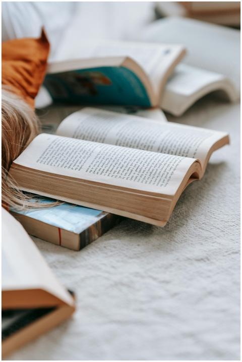 Close-up of open books on a soft, light-colored fa