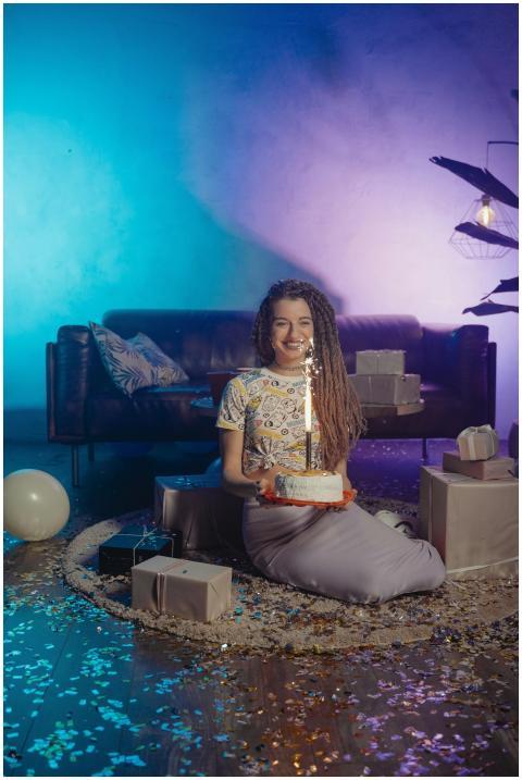 Woman sitting in a confetti-filled room holding a