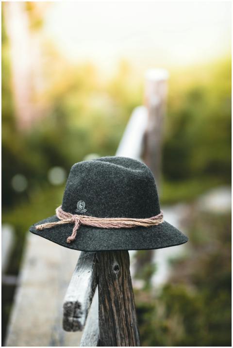 A felt hat resting on a wooden fence in a serene o