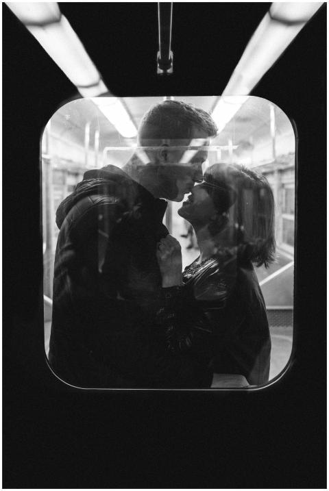Monochrome image of a couple kissing inside a subw