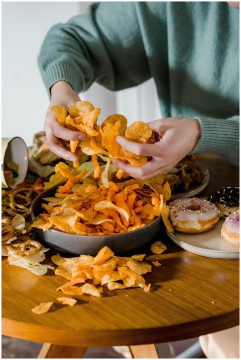 Unrecognizable female with tasty unhealthy crisps