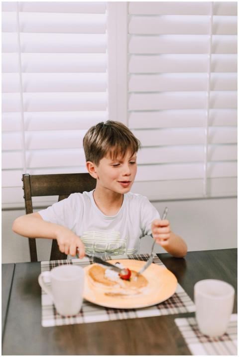 A child enjoying a breakfast meal at a dining tabl