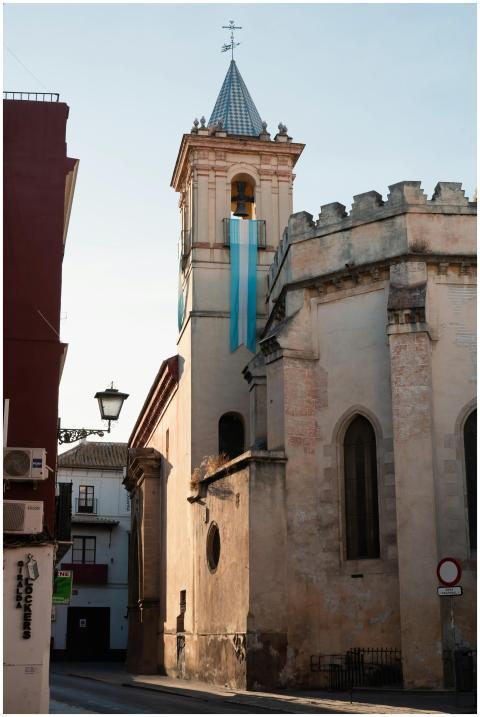 Gothic church tower with colorful banners in Sevil