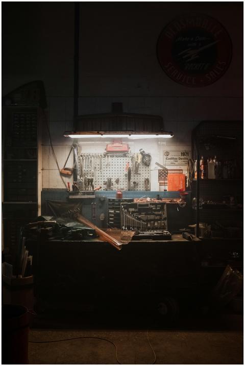 A moody, dimly lit workshop with neatly arranged t