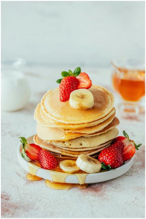 Stack of fluffy pancakes with strawberries, banana