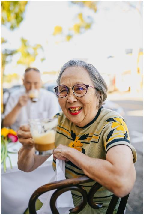 Happy elderly woman with coffee at an outdoor cafe