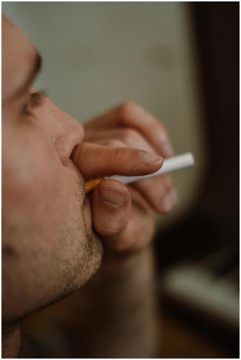 Indoor close-up of a man with facial hair smoking