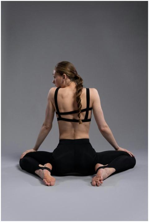 Woman in black sportswear stretching in yoga pose