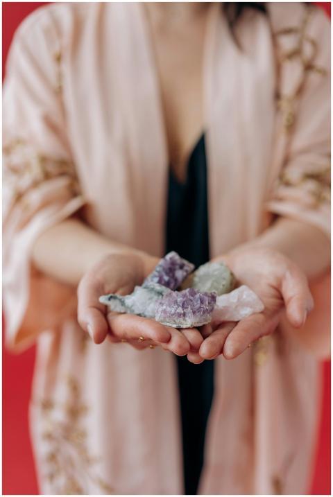 A woman gently holds healing crystals in her hands