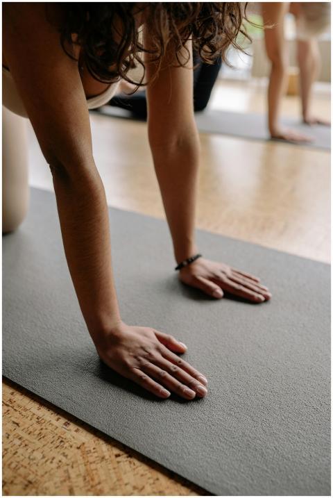 Close-up of a woman in a yoga pose on a mat, focus