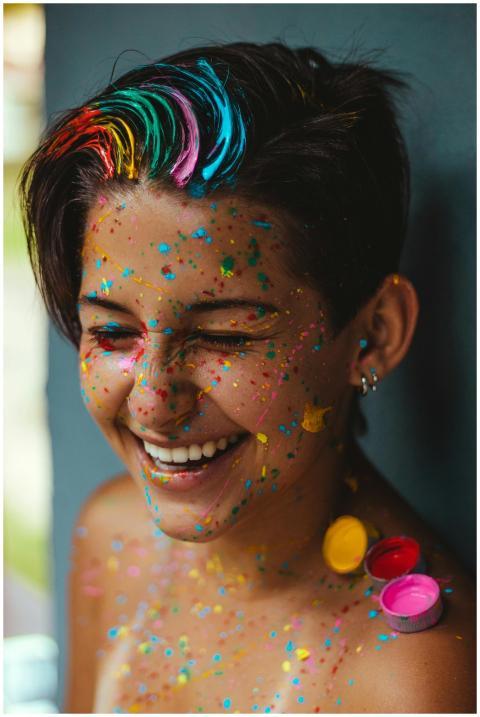 Smiling woman with vibrant face paint and colorful