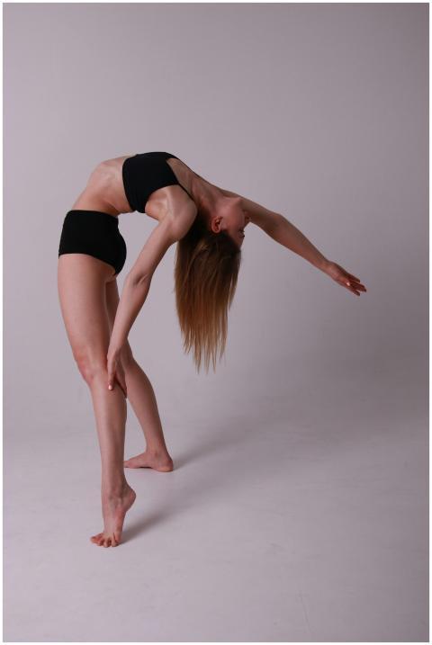 A woman elegantly performs a yoga pose in a studio