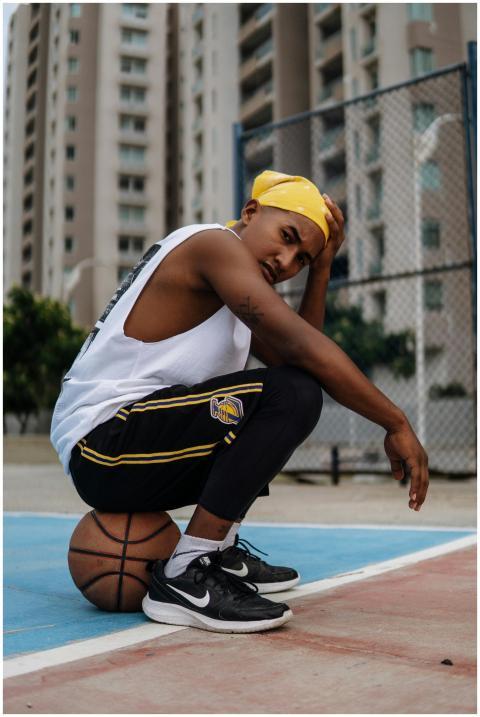 A stylish man posing on a basketball court with ci
