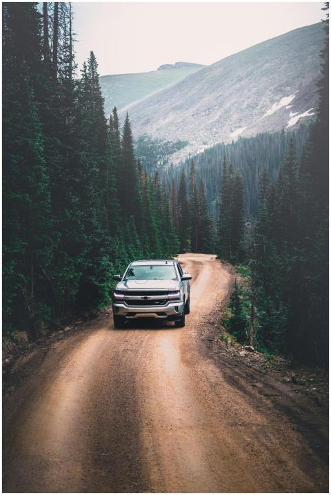 A rugged SUV navigates a scenic dirt road surround