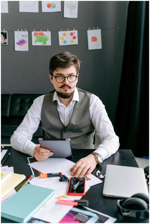 Businessman in a stylish vest working on a tablet