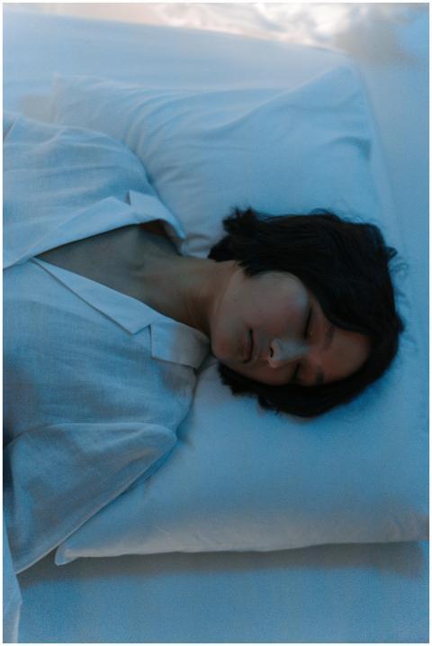 A peaceful woman sleeping on a pillow with eyes cl