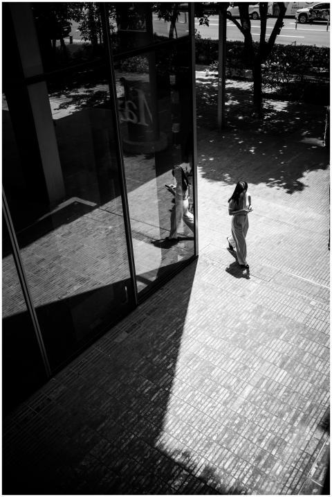 Black and white photo of a woman using a phone, re