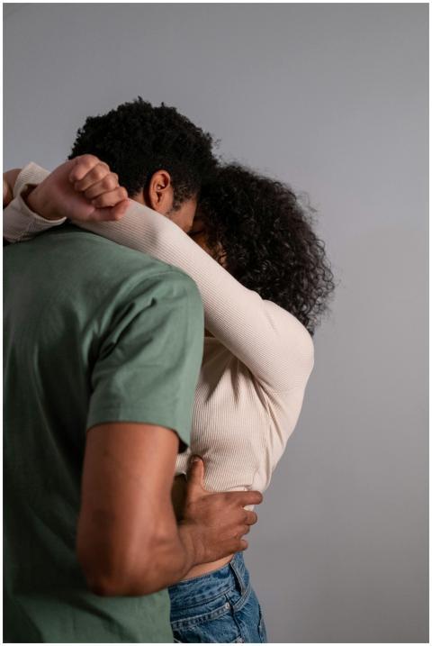 A couple shares an intimate embrace in a neutral s