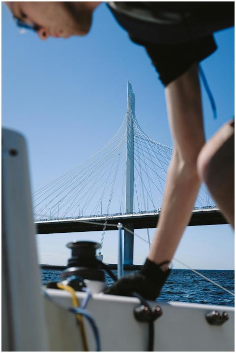 Man sailing near a modern cable stayed bridge on a
