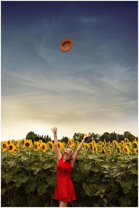 A carefree woman wearing a red dress and sunglasse