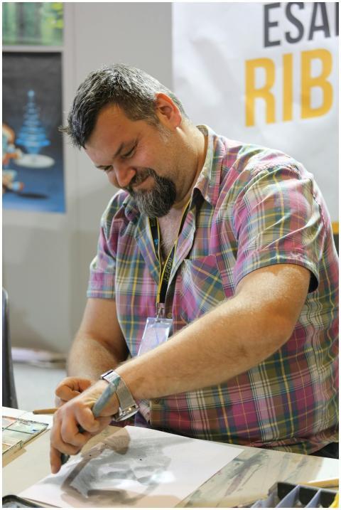 Happy artist sketching with concentration in indoo