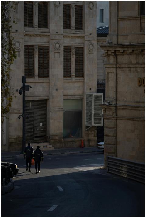 Two people walk along a quiet street in Baku's old