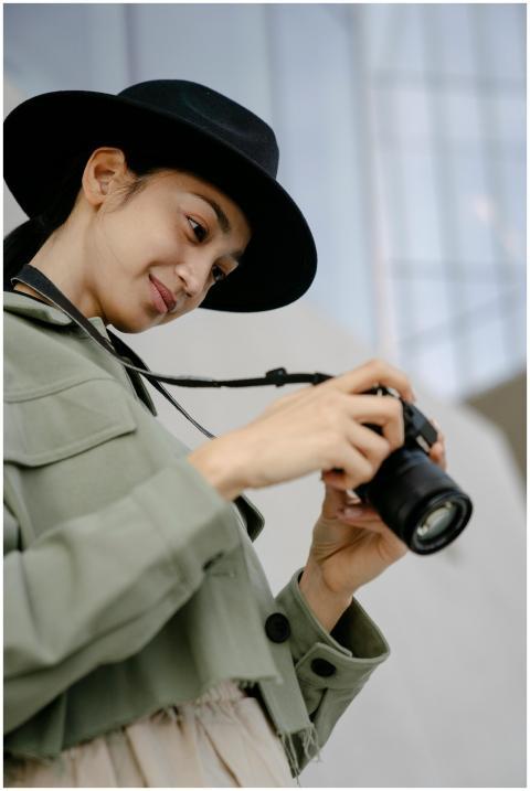 Young woman with a modern camera and stylish hat,