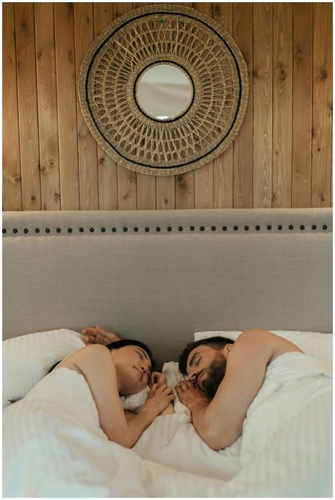 A serene couple resting in bed under cozy blanket