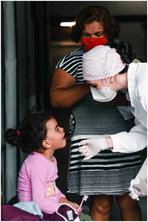 A healthcare professional examines a young girl in