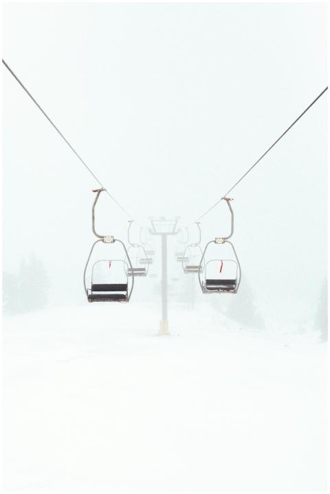 Empty ski lift in foggy winter scene highlighting