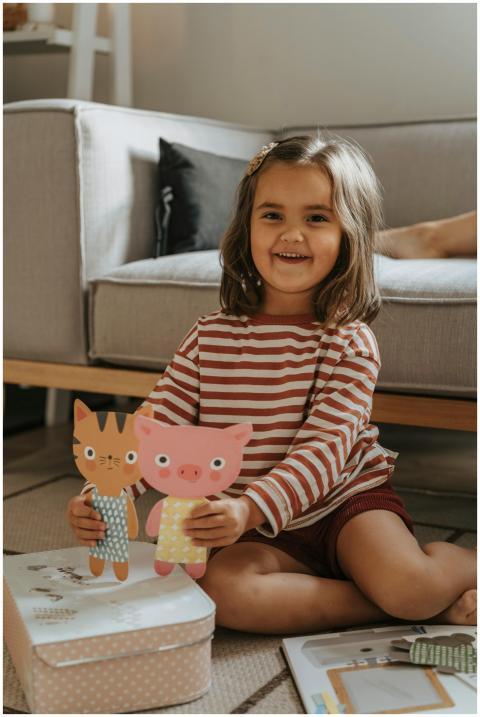 Smiling child in striped shirt happily playing wit