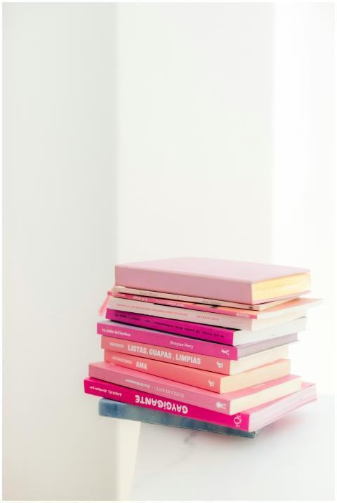 A neat stack of books with pink covers on a white