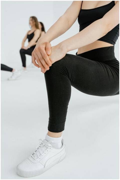 Group of women in activewear doing lunges indoors