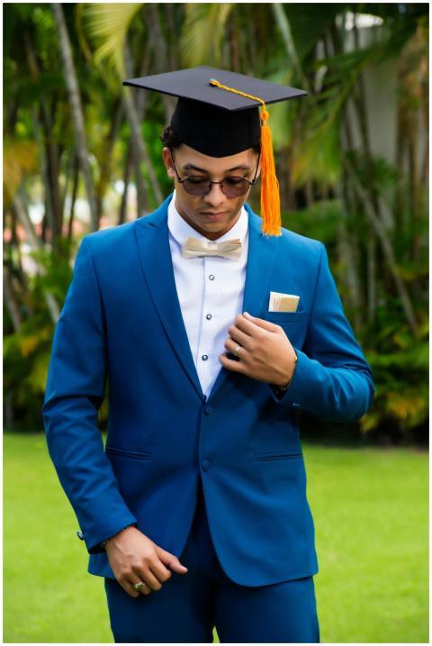 Dapper young graduate in blue suit with cap and ta