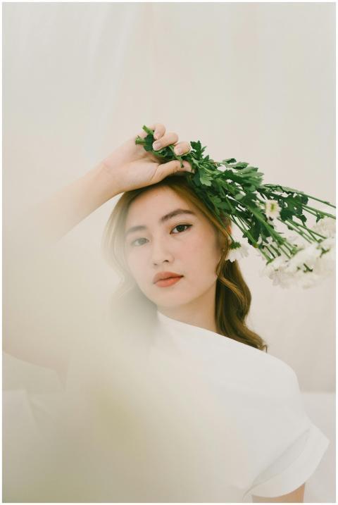 A stylish woman poses with flowers, exuding grace