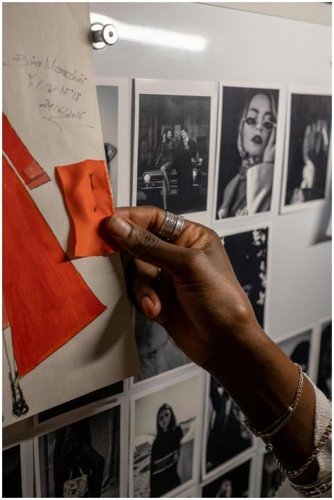 A designer's hand holding fabric against a mood bo