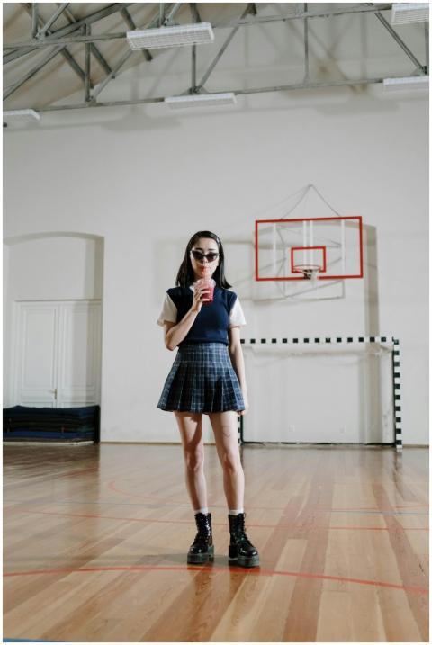 Teenage girl in school uniform holding a drink in