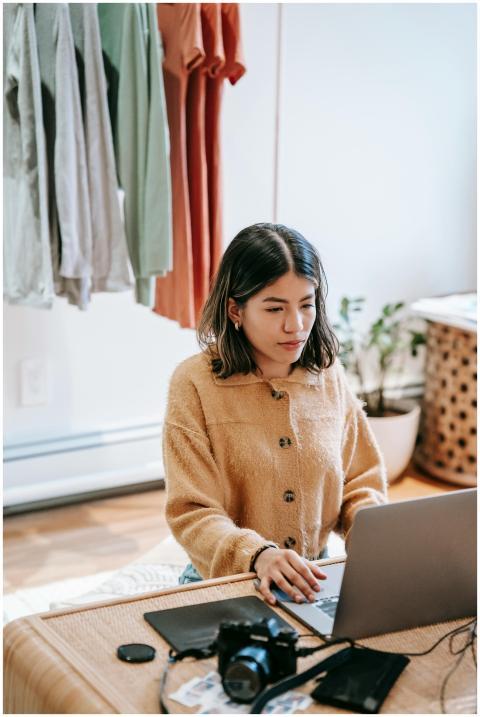 A young woman focuses on her laptop in a home offi